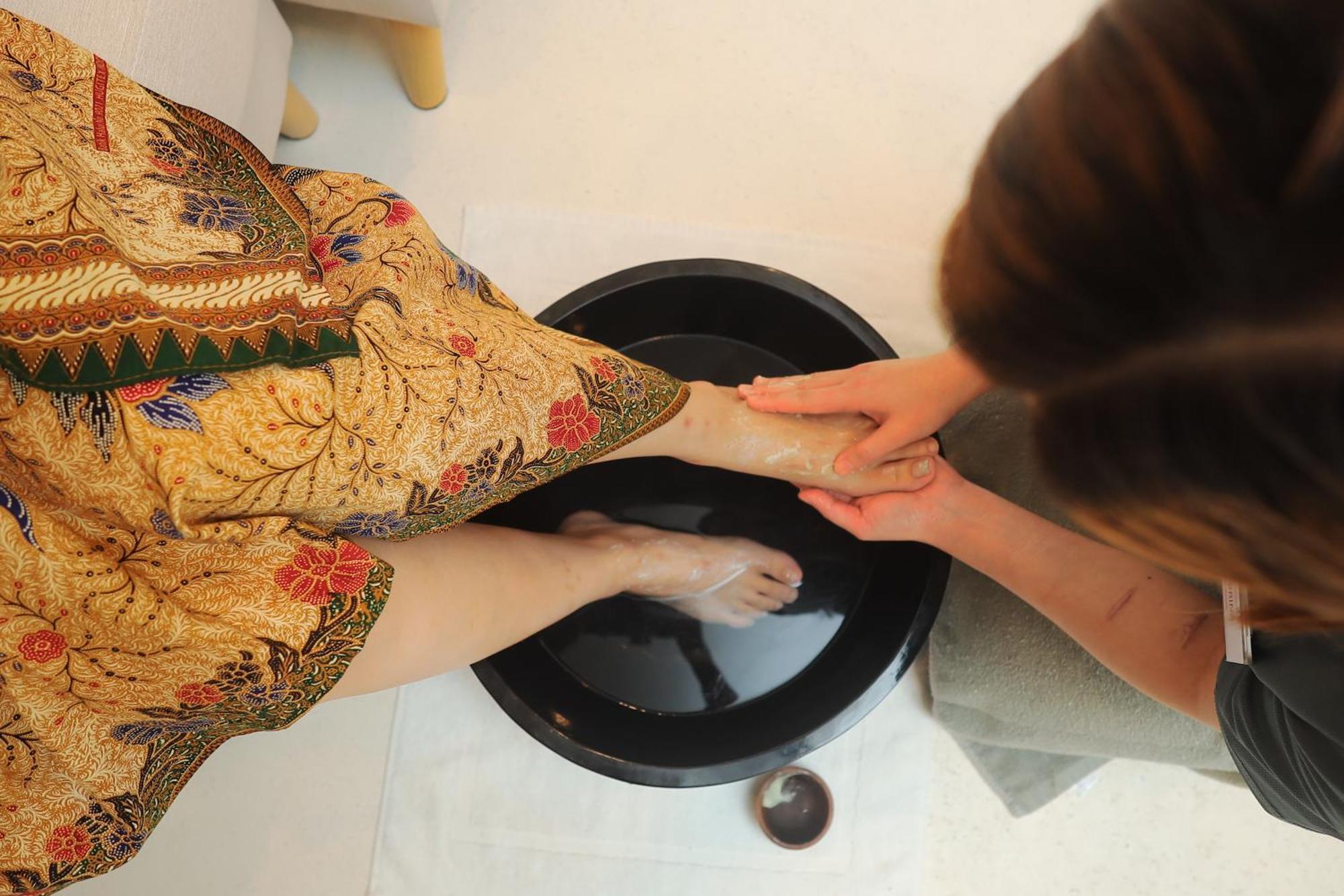 The Riyaz Lavanya Langkawi ปันไตเจอนัง ภายนอก รูปภาพ A woman washing the feet of a guest